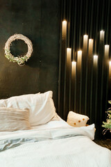 Decorations with garlands and a Christmas wreath. Cozy atmosphere of a home holiday, loft-style interior design. A wreath in close-up on a dark wall.