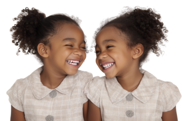 Two smiling twin girls sharing moment of laughter and joy isolated on white background