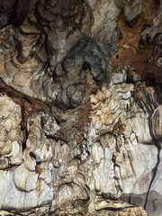 Overhead view of rough, layered, and textured cave walls with geological features and rock formations.