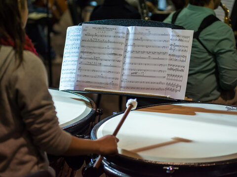 Drummer in an orchestra reading the music score
