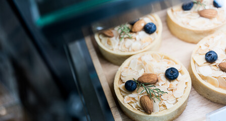 Small tartlets with nut filling toppings an almond in showcase at cafe
