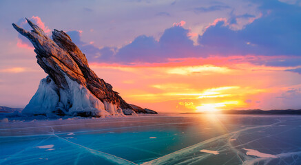 Beautiful winter landscape of frozen Lake Baikal at sunrise - A granite rock with steep slopes...