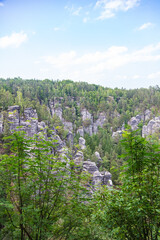Impressive sandstone formations in Saxon Switzerland National Park near Rathen, Germany, surrounded by dense forest and blue sky – a perfect destination for nature lovers and hikers.