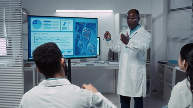 Medium full shot of group of multiethnic bioengineering university students attending seminar on DNA and genetics, listening to black male professor giving lecture with presentation, asking questions