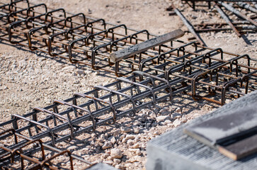 steel reinforcement bars on gravel ground at construction site prepared for concrete foundation...