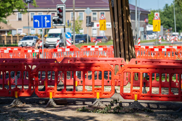 urban construction site with orange safety barriers traffic signs and roadwork equipment blocking...