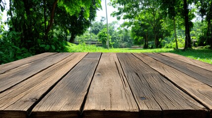 A wooden deck extends into a lush green park with tall trees and vibrant grass under bright sunlight