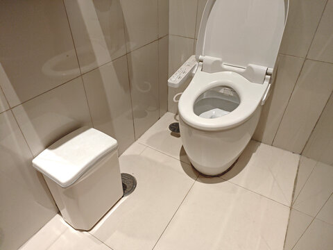 Modern bathroom interior with clean toilet and waste bin