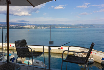 Table in a cafe on a panoramic terrace over the marina in Opatija, Croatia, with the city of Rijeka in the background