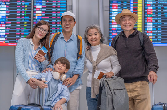 portrait three generations family standing in front of departure schedule for airlines travel in international airport terminal,family lifestyle,journey on summer vacation trip
