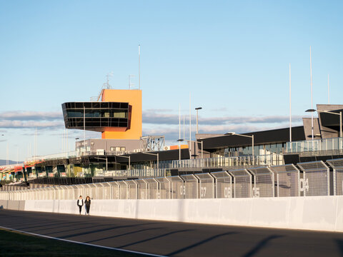 Two walkers walking up Pit Straight on the Mount Panorama Racing Circuit