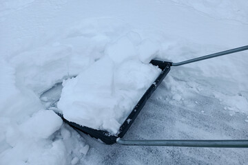 Large snow shovel. Clearing in the city after a snowfall