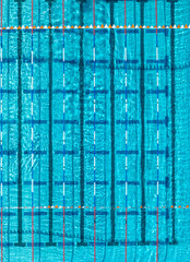 Top view of a swimming pool with swimming lanes and rippling blue water