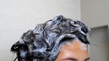 woman is taking a shower and washing her hair in the bathroom