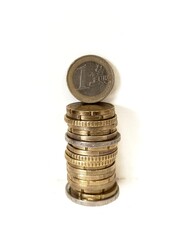 Stack of euro coins on white background with one euro coin in foreground. Concept for finance, savings, or investment.