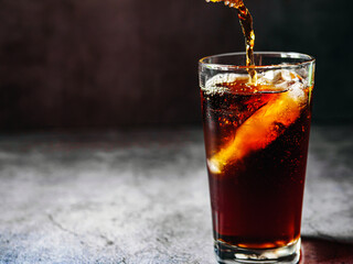 Pouring of Cola and Ice, Cola soft drink with ice cubes, soda fizzy drink in Cold glass