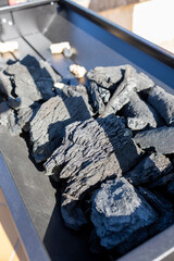 Charcoal briquettes resting in a grill, ready for cooking