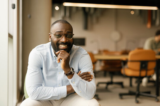 Smiling office worker in a modern coworking space looking at the camera