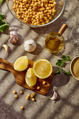 Chickpeas, lemon, tahini and herbs, ingredients for making hummus. Top view.
