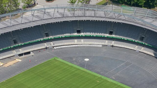 darius and girenas stadium with tiered seating, a running track, and a vibrant green sports field