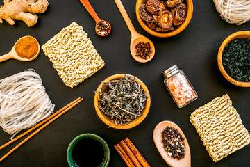 Chinese and Japanese food cooking with ginger, spices and noodles on black background top view geometric pattern