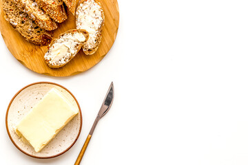 Slice of bread with butter on white background top view copy space