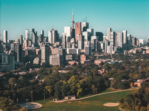 Toronto skyline with CN Tower and urban park.