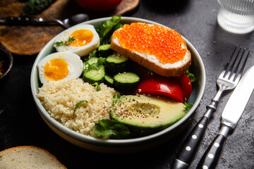 Couscous with boiled egg and vegetables in a plate on the table