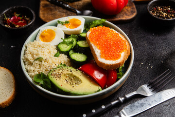 Couscous with boiled egg and vegetables in a plate on the table
