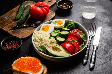 Couscous with boiled egg and vegetables in a plate on the table