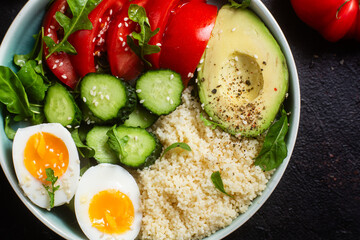 Couscous with boiled egg and vegetables in a plate on the table