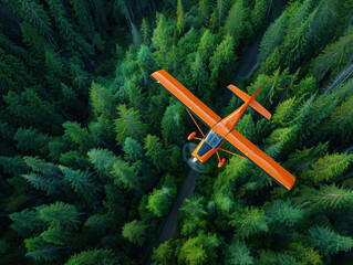 Оrange airplane captured from above fly over a dense green forest, showcasing nature beauty of the landscape