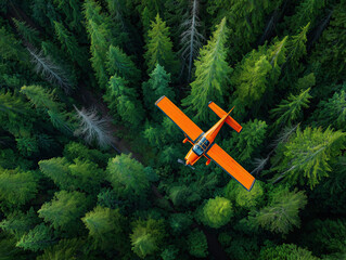 Оrange airplane captured from above fly over a dense green forest, showcasing nature beauty of the landscape