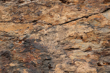 vista macro di una superficie di roccia naturale dalle sfumature di grigio scuro e marrone chiaro sbiadito