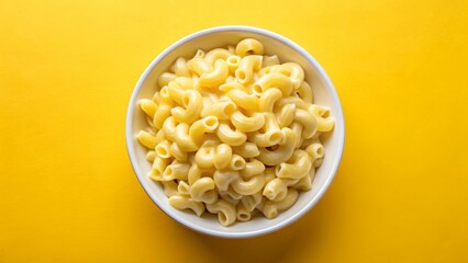 A bowl of creamy macaroni and cheese sits on a yellow background