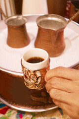 Closeup of Turkish Coffee with the Boilers Called Cezve Placed on the Hot Sand in the Backdrop