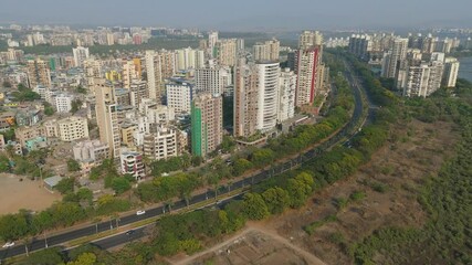 Aerial view of flamingos with buildings and lake, India.
