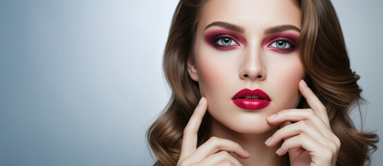 Fototapeta premium Woman with glamorous red smokey eye makeup and matching lipstick. Professional evening look for a special event. For beauty salon and cosmetics advertising. Banner with copy space