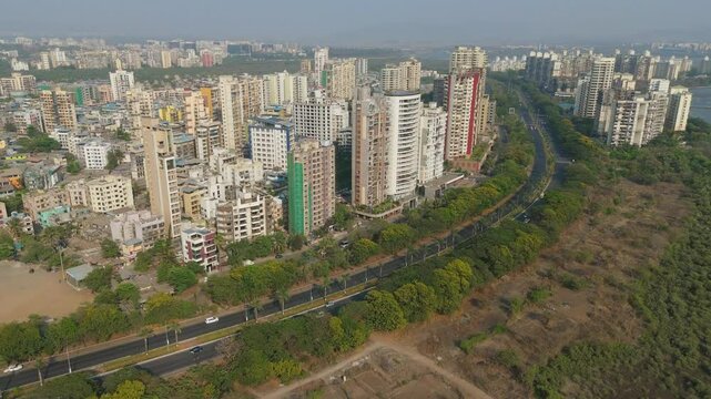 Aerial view of flamingos with buildings and lake, India.