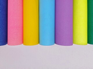 Colorful rolled paper lined up isolated on white background. Side view angle. 