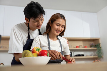 Couple Cooking Together. Smiling partners preparing a meal in a cozy kitchen.