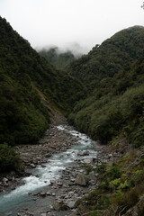 Powerful, dynamic river carving through a dramatic, moss-drenched valley. The turquoise water...