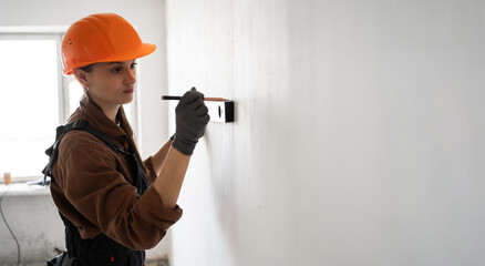 building and profession concept. Female builder with spirit level holding measuring tool indoors.