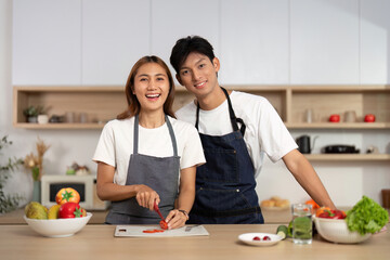 Couple Smiling While Preparing Food in Kitchen. Engaging in healthy cooking together.