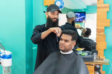 Hairdresser cutting hair of customer in beauty salon