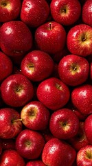 A close-up view of freshly harvested red apples, glistening with droplets. Vivid colors and varied shades create an inviting, wholesome aesthetic, ideal for showcasing healthy eating or farm freshness