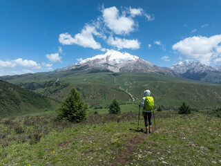 Backpacking woman hiking on grassland mountains