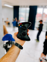 Enthusiastic gamer showcases controller in modern event space during gaming session