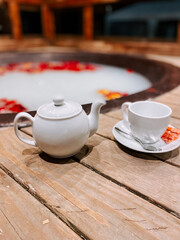 Relaxing tea moment by a tranquil flower bath at a cozy retreat
