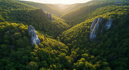 Panoramic summer view of green mountain ranges and valleys from a scenic peak under a cloudy sky